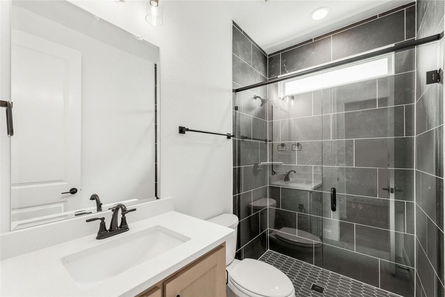 Bathroom with white vanity, walk-in glass shower with dark gray tile, and black hardware fixtures