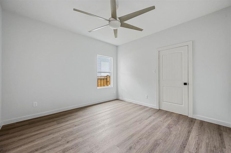 Bedroom 1 with light hardwood / wood-style floors and ceiling fan