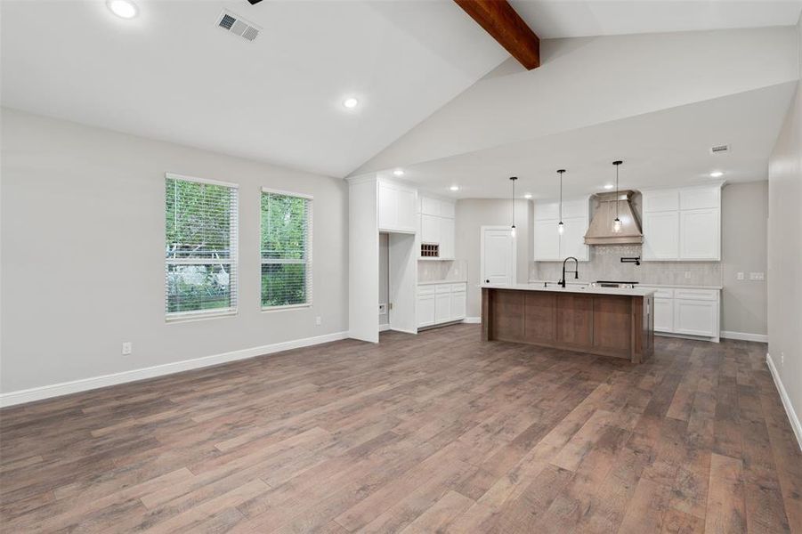 Kitchen featuring white cabinets, recessed lighting, tasteful backsplash, an island with sink, and custom exhaust hood