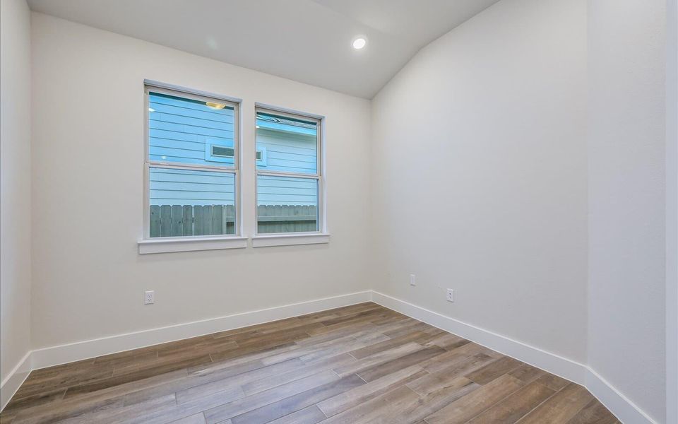 Spare room with light wood finished floors, vaulted ceiling, and recessed lighting
