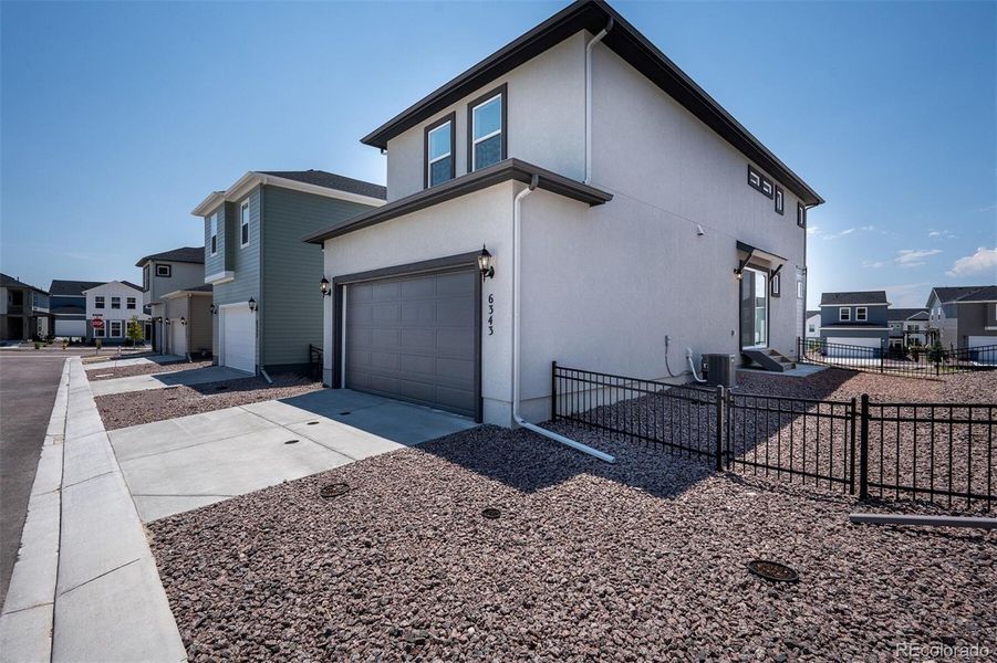 Front exterior of a new home in Revel Crossing at Wolf Ranch – The Ascent Collection, Colorado Springs, CO, highlighting curb appeal (Image 1).