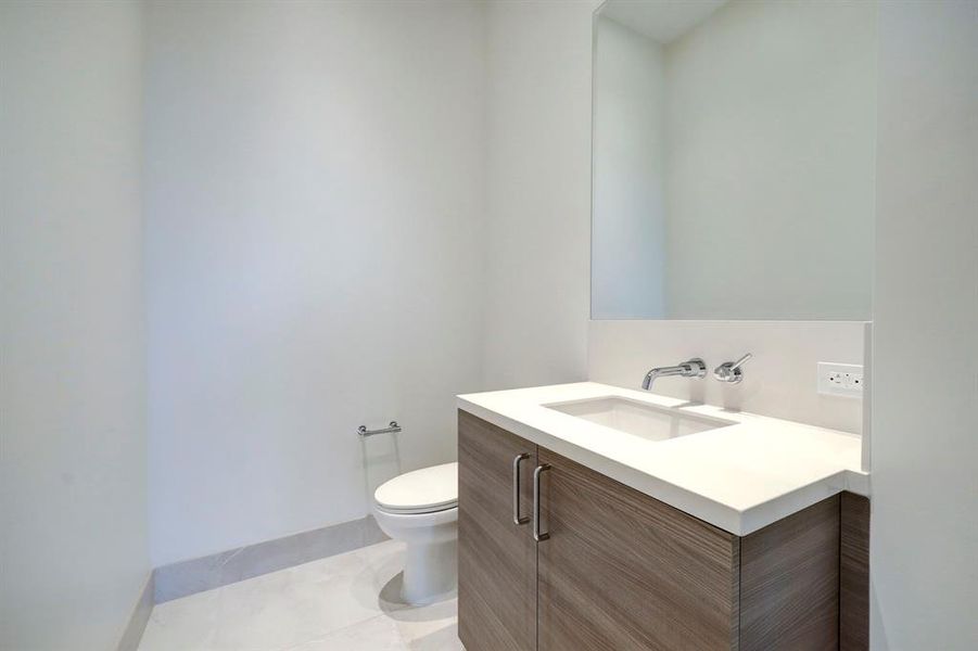 Conveniently located near the entry and great room, the powder room offers beautiful tile, a large vanity and contemporary polished chrome hardware.