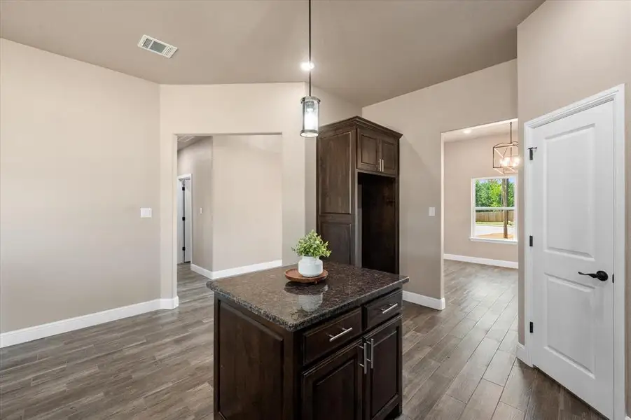 Kitchen island with a dark wood finish and granite countertop