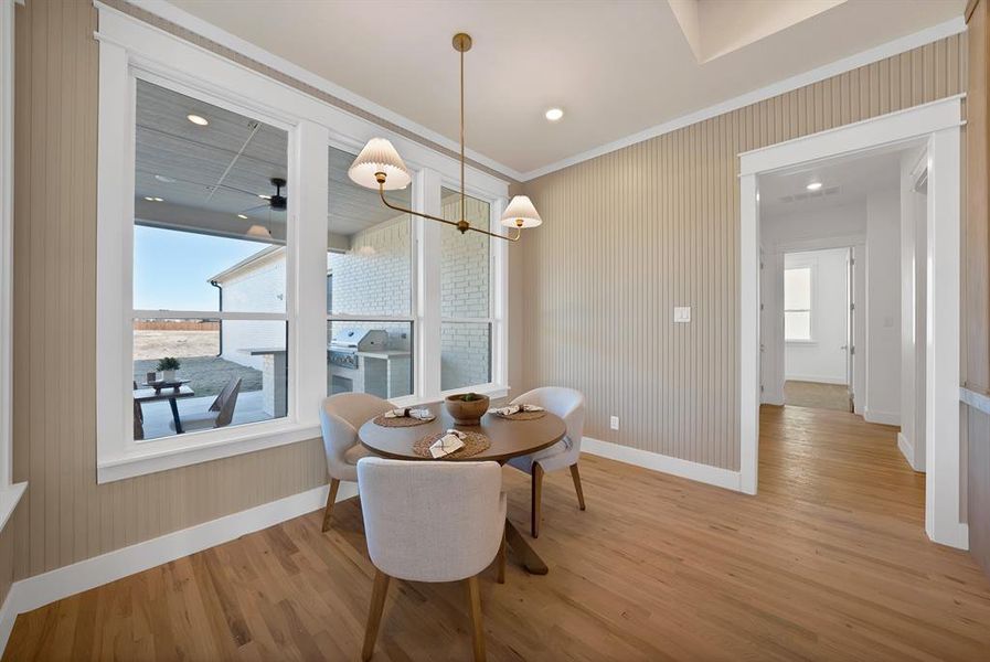 Dining room featuring a chandelier, light wood-style flooring, crown molding, and recessed lighting