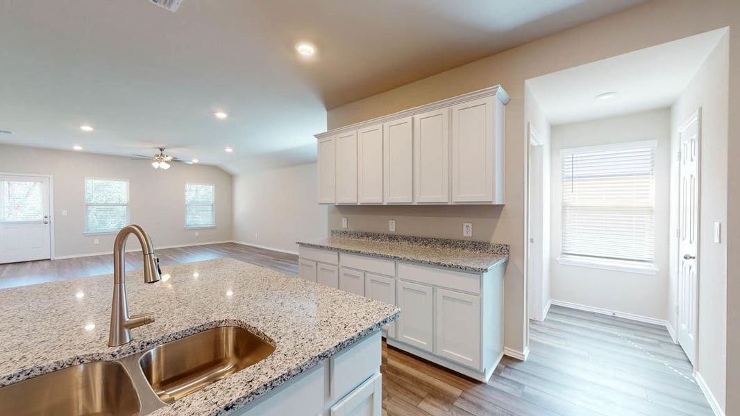 Kitchen featuring white cabinets, light wood-style flooring, healthy amount of natural light, recessed lighting, and ceiling fan