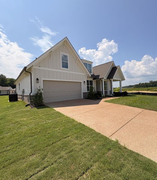 Modern farmhouse exterior with cream-colored siding and a two-car garage Modern farmhouse exterior with cream-colored siding and a two-car garage