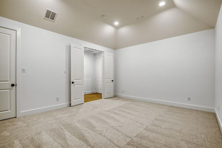 Unfurnished bedroom featuring lofted ceiling, light carpet, and recessed lighting