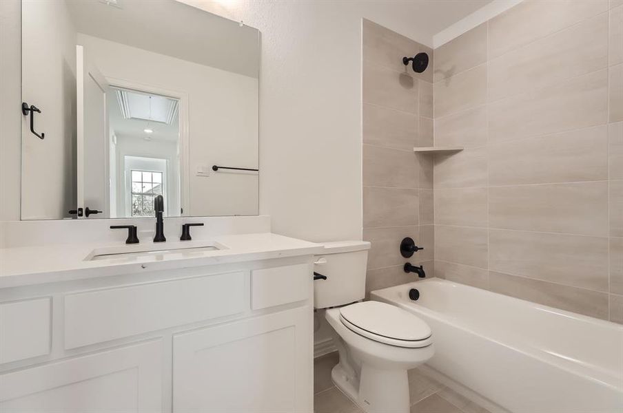 Full bathroom with toilet, tiled shower / bath, vanity, and tile patterned flooring