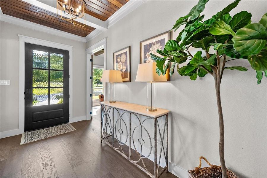 Entryway featuring crown molding, a chandelier, hardwood wood floors, and wooden ceiling!