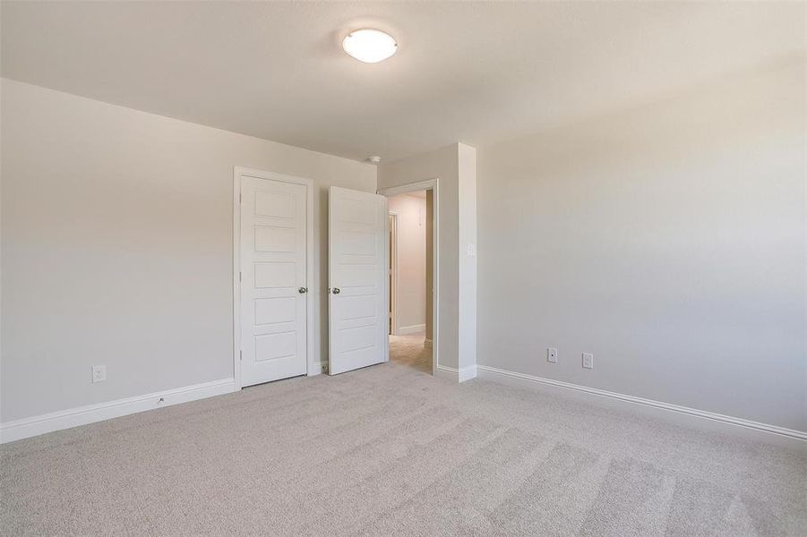 Unfurnished bedroom with light carpet and baseboards Unfurnished bedroom with light carpet and baseboards