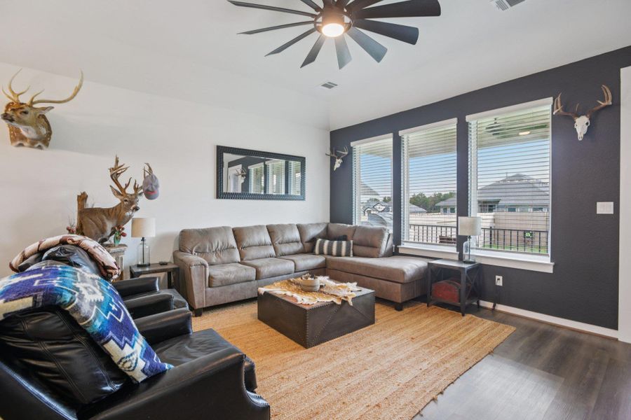 Living area with wood finished floors, a ceiling fan, and lofted ceiling Living area with wood finished floors, a ceiling fan, and lofted ceiling
