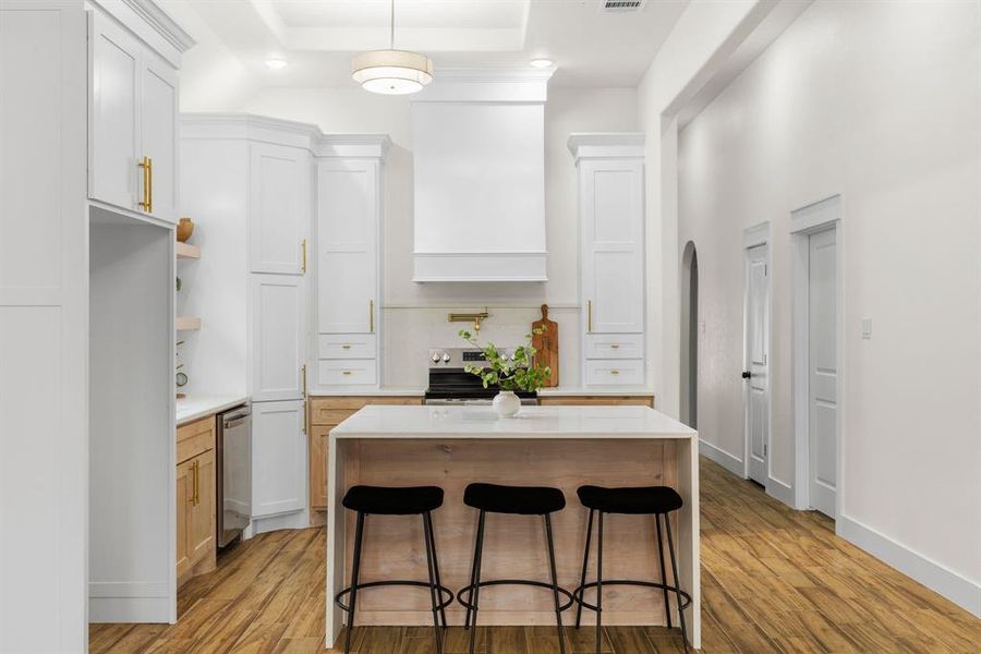 Kitchen with a center island, white cabinetry, and light hardwood / wood-style flooring