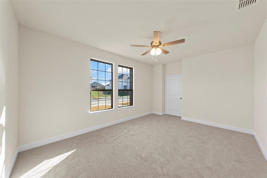 Carpeted spare room with ceiling fan