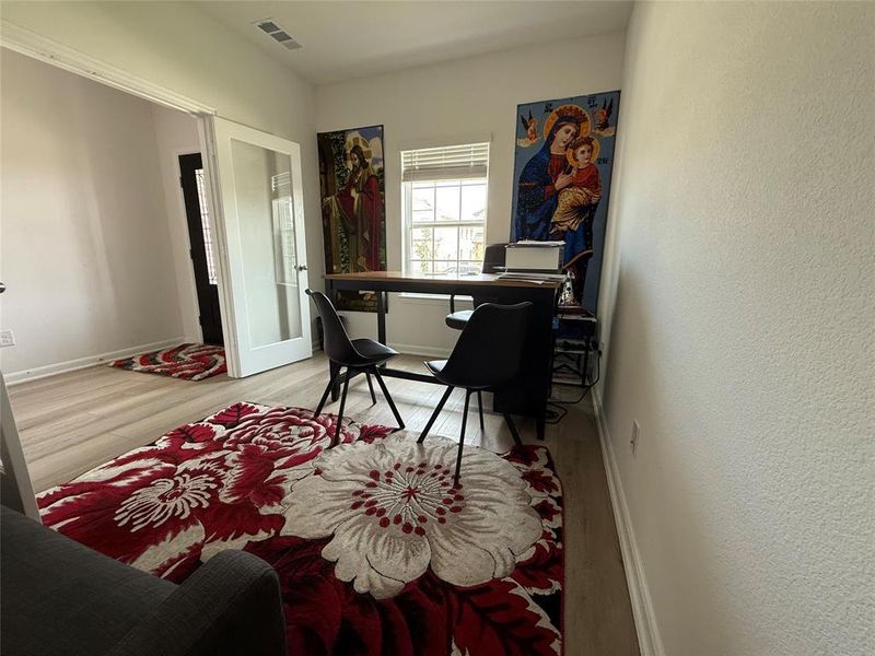 Room featuring wood-finish flooring, white baseboards, and neutral wall paint