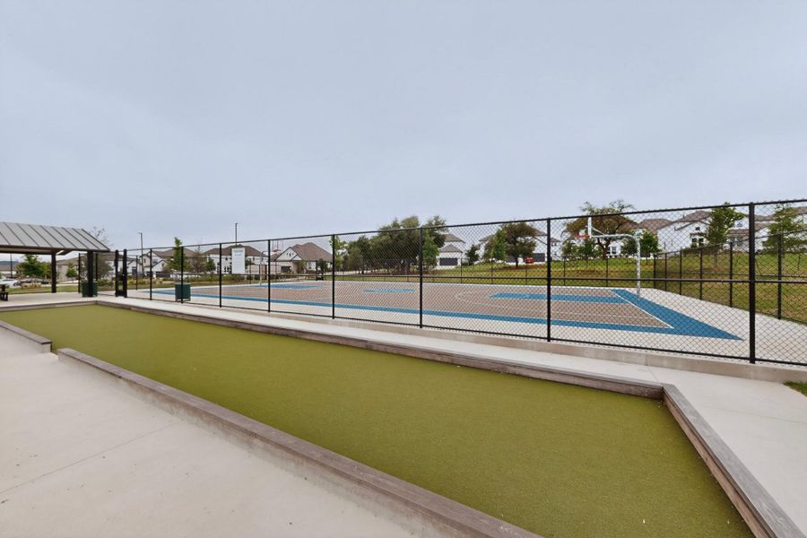 Recreational area featuring a bocce ball court, fenced sports court with basketball hoop, and a covered pavilion