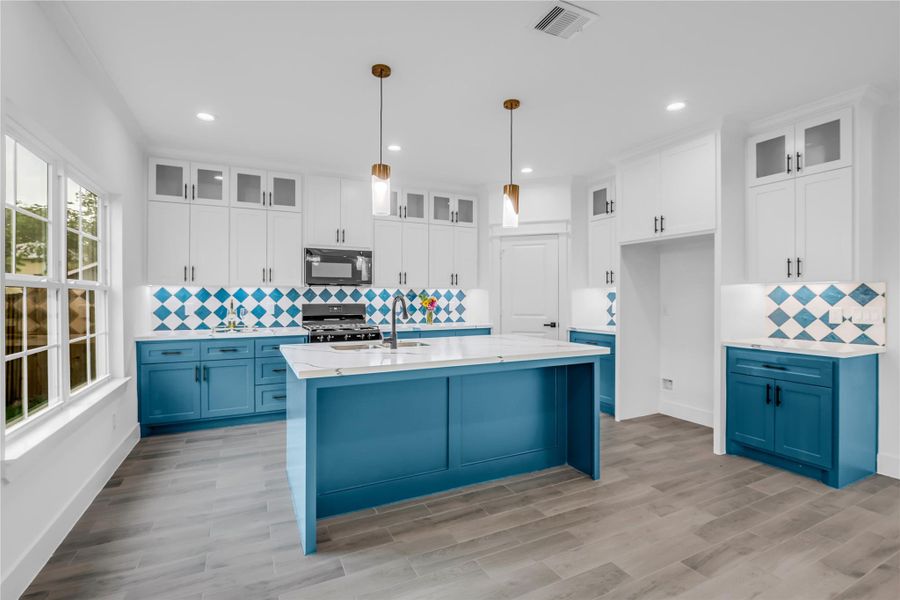 This kitchen and dining room blend modern elegance with a splash of color, featuring sleek cabinetry, eye-catching blue accents, and an inviting open layout perfect for entertaining.