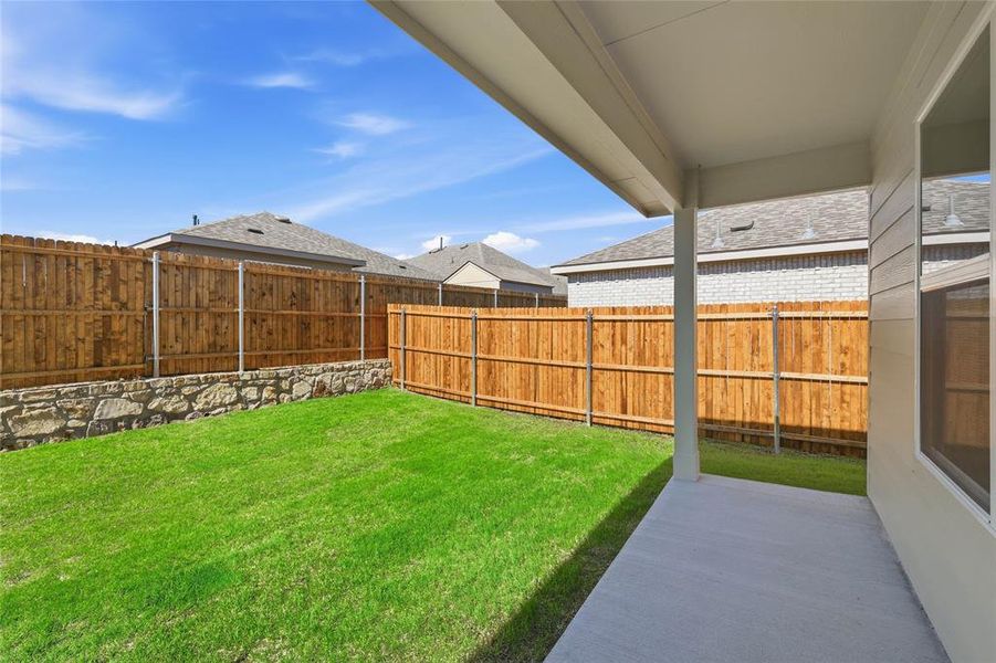 Fenced backyard with a patio area