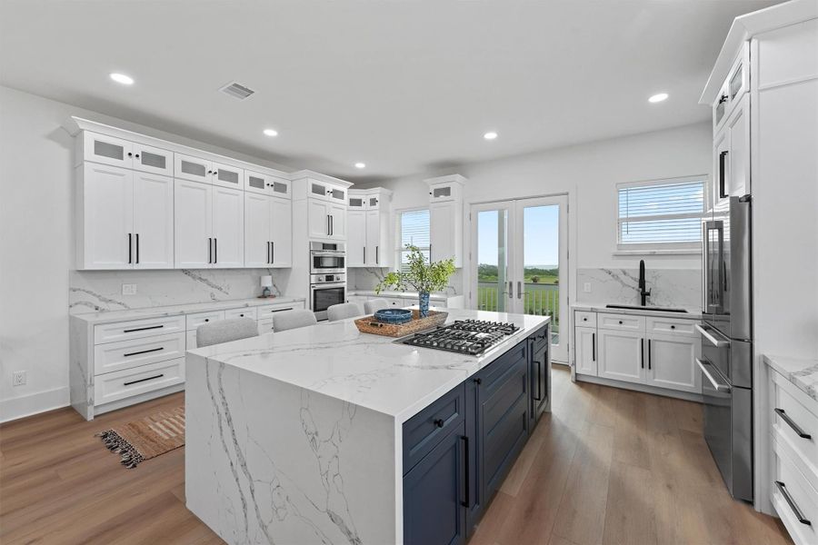 Another angle of the chef’s kitchen reveals the full layout—double ovens, high-end gas range, and seating for a crowd. Another angle of the chef’s kitchen reveals the full layout—double ovens, high-end gas range, and seating for a crowd.