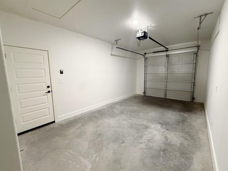 Garage with baseboards and a garage door opener Garage with baseboards and a garage door opener