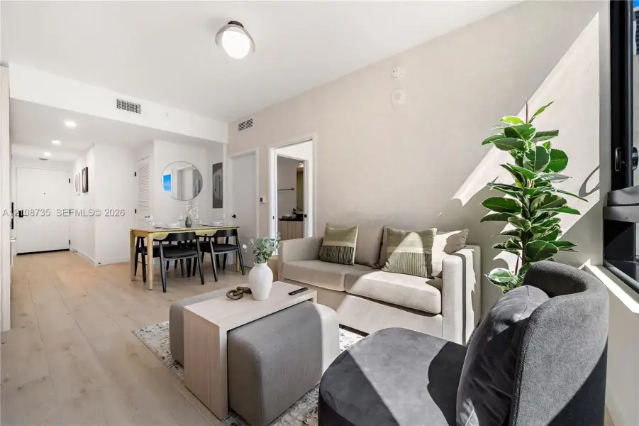 Open-concept living space featuring wood-finish flooring, recessed lighting, and large window Open-concept living space featuring wood-finish flooring, recessed lighting, and large window