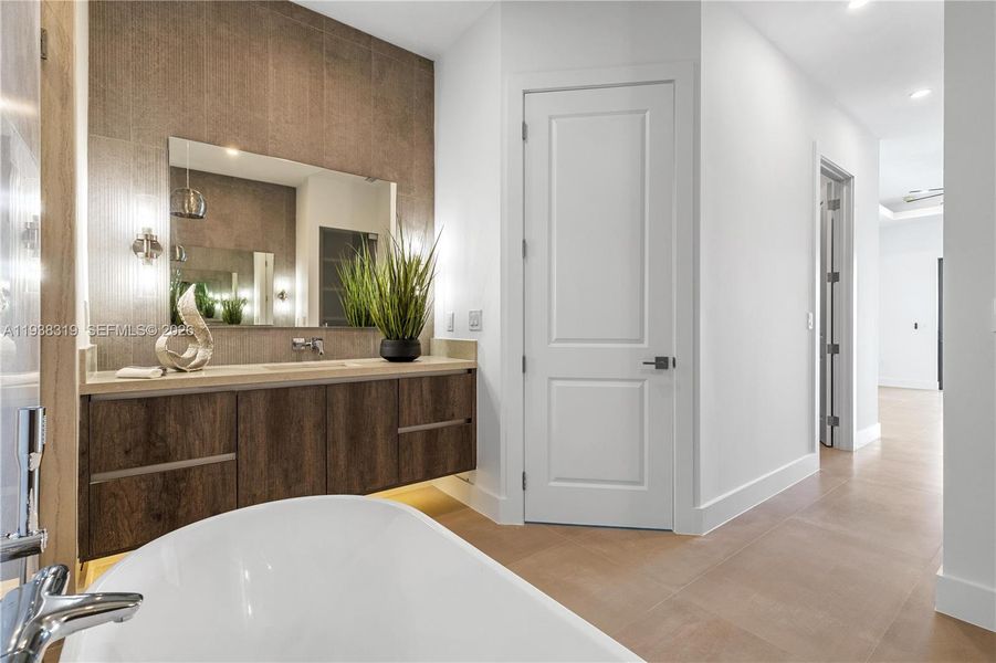 Custom vanities, wall-mounted faucets, quartz countertops, and an electric toilet.