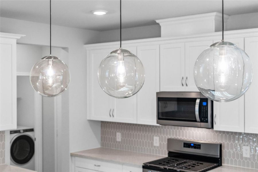 Atwell Pendant Brushed Nickel lights that hang over the kitchen island.