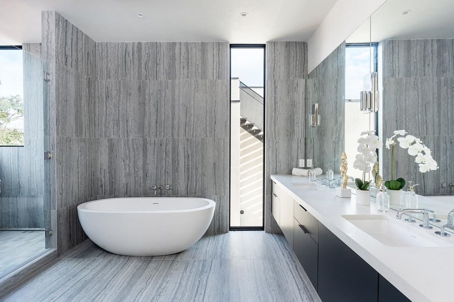 A spacious, naturally illuminated bathroom features a freestanding soaking tub and dual vanity. A spacious, naturally illuminated bathroom features a freestanding soaking tub and dual vanity.