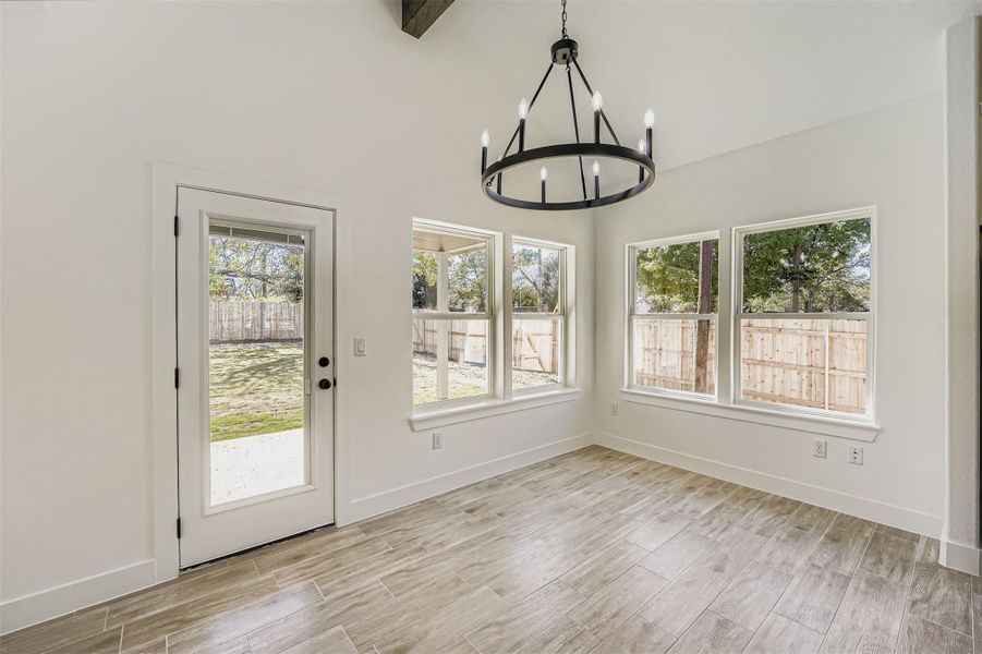 Dining area featuring a chandelier and wood-style vinyl plank floors Dining area featuring a chandelier and wood-style vinyl plank floors