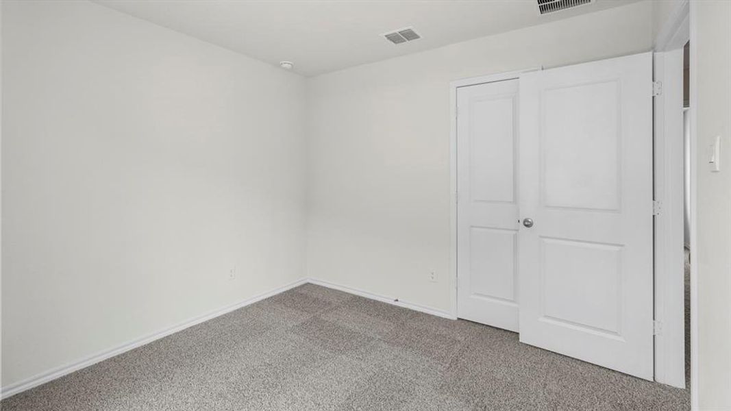 This room features light-colored walls, gray carpet, and white paneled doors
