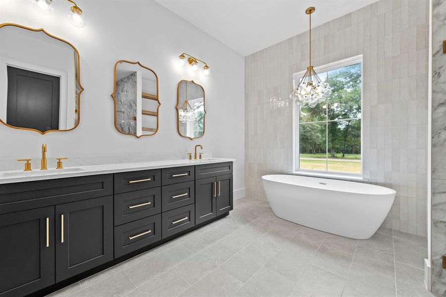 Gold hardware and elegant modern fixtures and lighting provide a true spa feel.