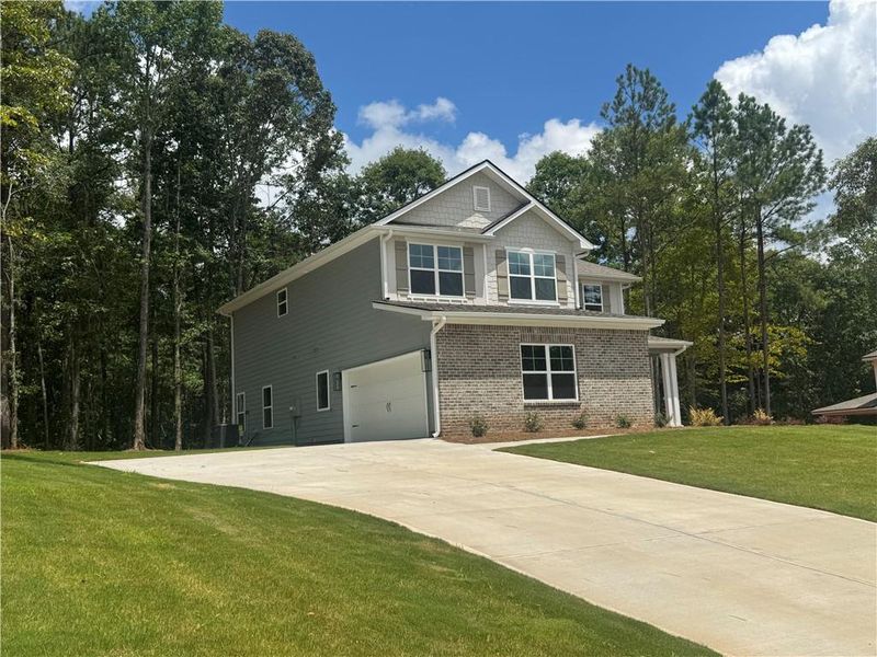 Front exterior of a new home in The Fields of Walnut Creek, Pendergrass, GA, highlighting curb appeal (Image 19). Front exterior of a new home in The Fields of Walnut Creek, Pendergrass, GA, highlighting curb appeal (Image 19).