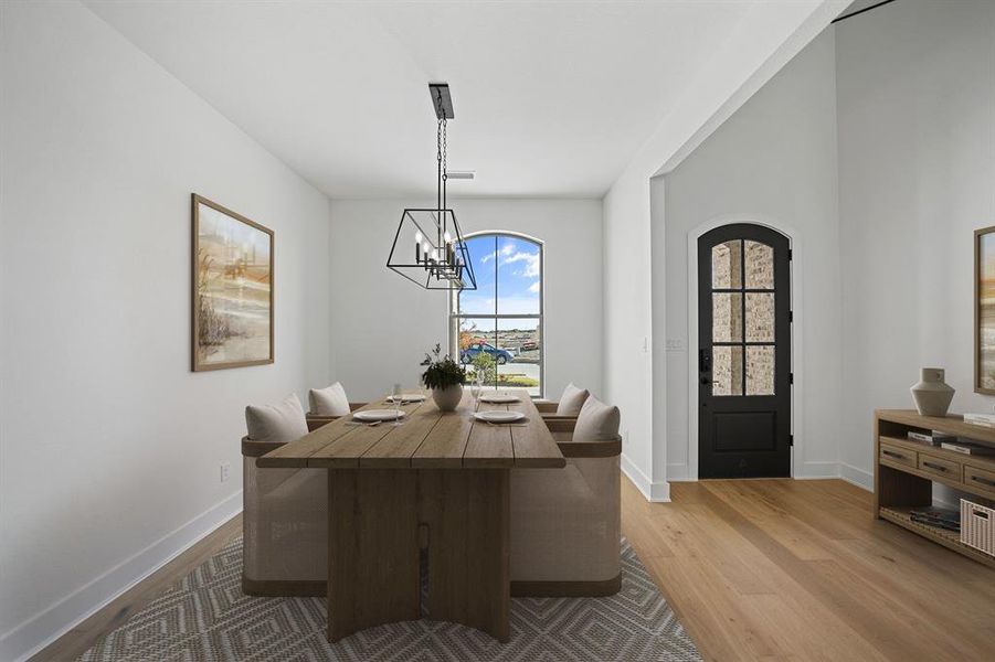 Dining space with light wood finished floors and a chandelier
