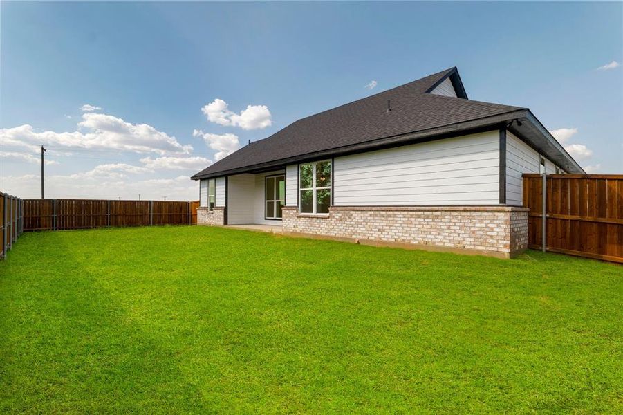 Back of house with a lawn