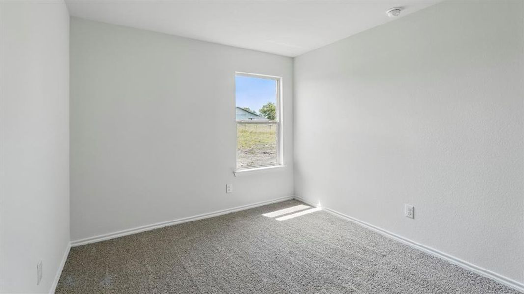 Carpeted spare room with baseboards