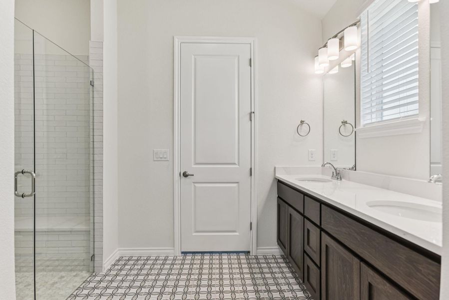 Full bath featuring double vanity and a shower stall Full bath featuring double vanity and a shower stall
