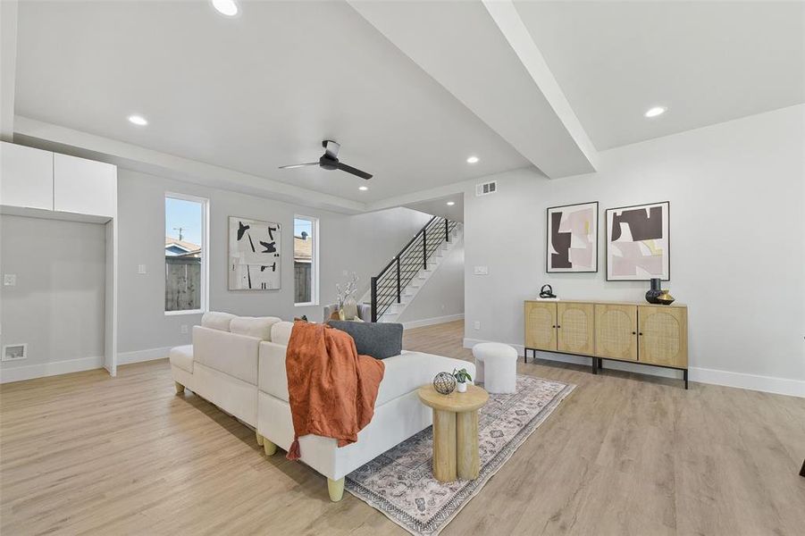 Living room with ceiling fan and light hardwood / wood-style floors