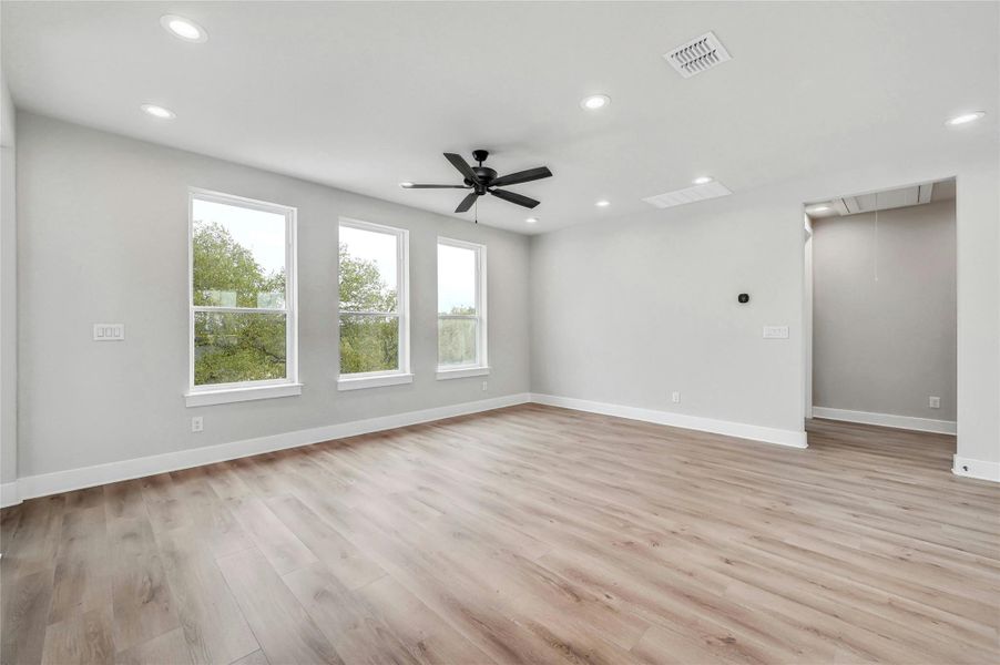 Empty room with visible vents, light wood finished floors, attic access, and recessed lighting