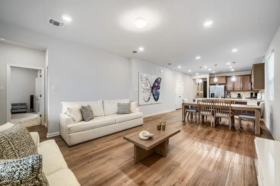 Open concept living area featuring wood-finish flooring, recessed lighting, and light-toned wall finishes