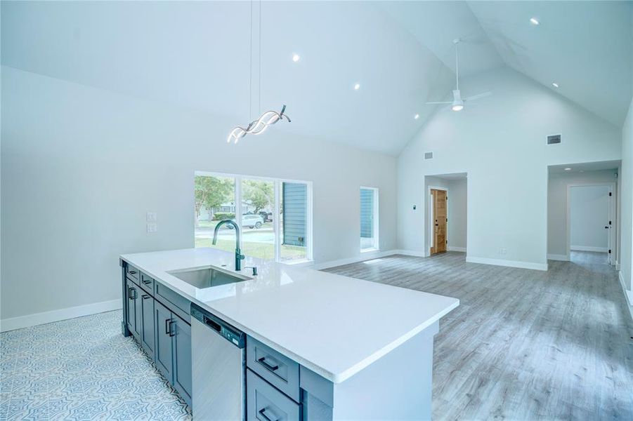Contemporary kitchen island with a built-in stainless steel sink, modern faucet, and white countertop