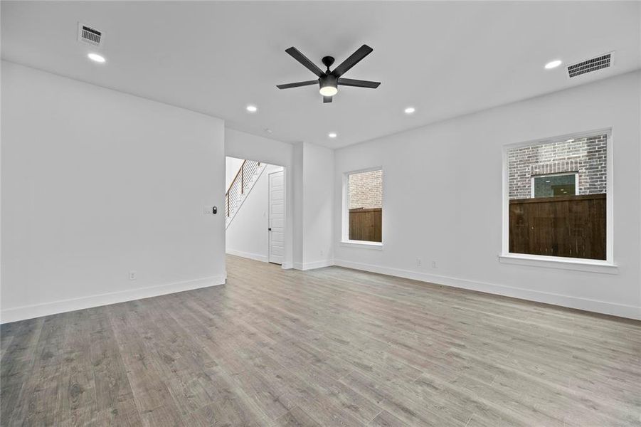 Spare room featuring stairway, wood finished floors, a ceiling fan, and recessed lighting Spare room featuring stairway, wood finished floors, a ceiling fan, and recessed lighting