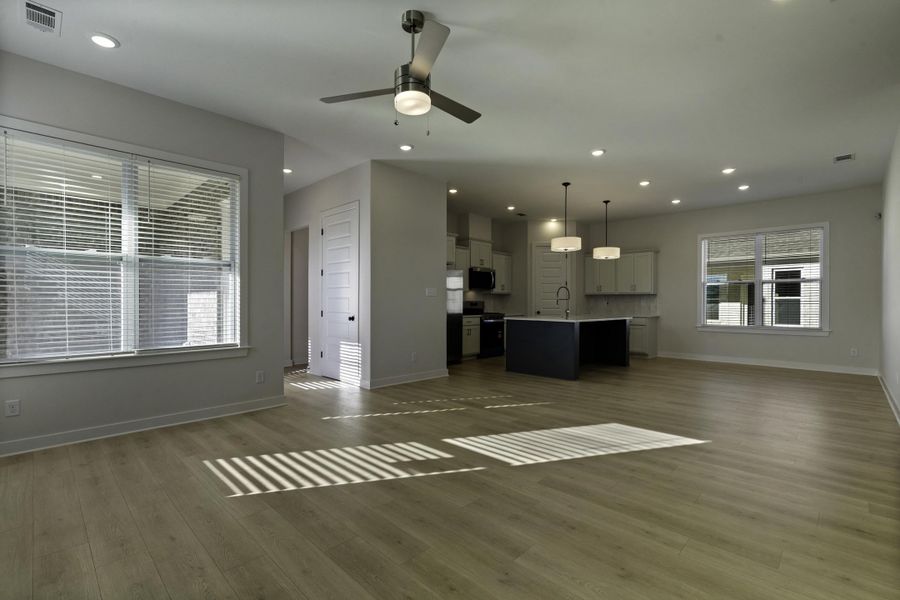 Open-concept living area featuring wood-finish flooring, recessed lighting, and a ceiling fan