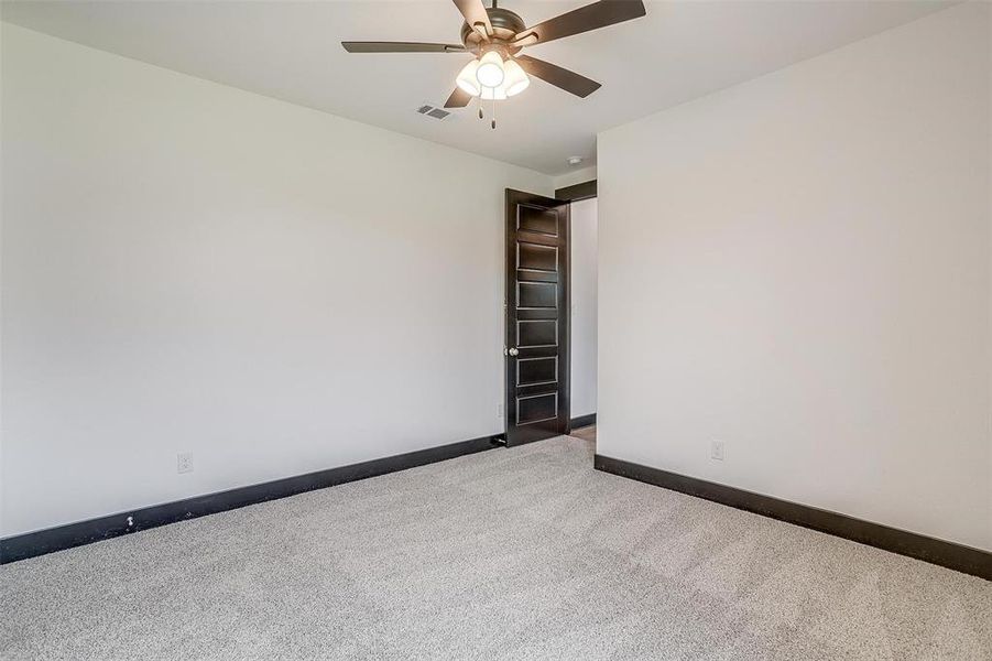 Unfurnished room featuring ceiling fan and carpet floors