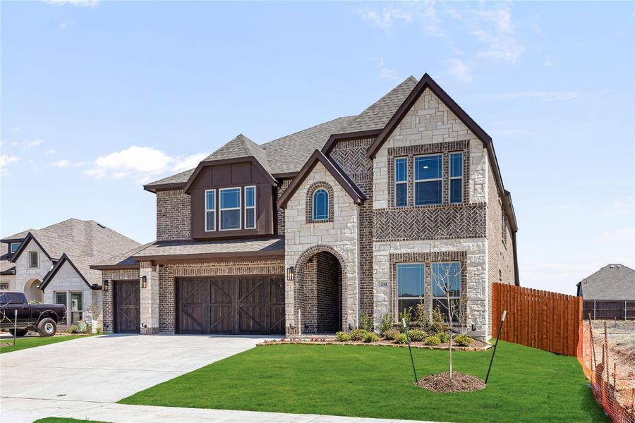Two-story home with brick and stone exterior, arched entry, two-car garage, and manicured front lawn Two-story home with brick and stone exterior, arched entry, two-car garage, and manicured front lawn