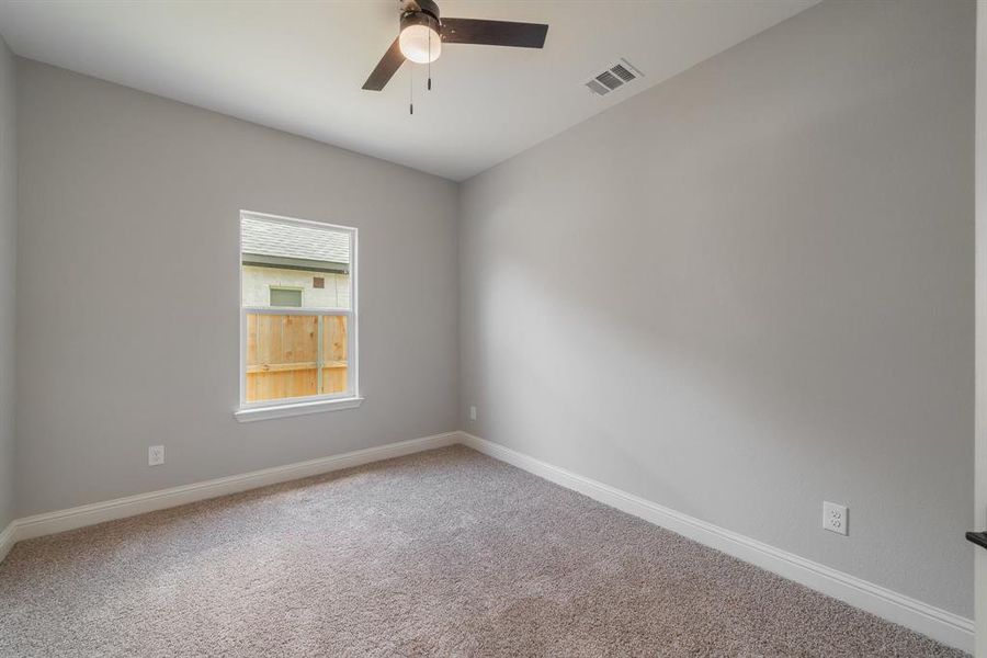 Carpeted empty room featuring ceiling fan