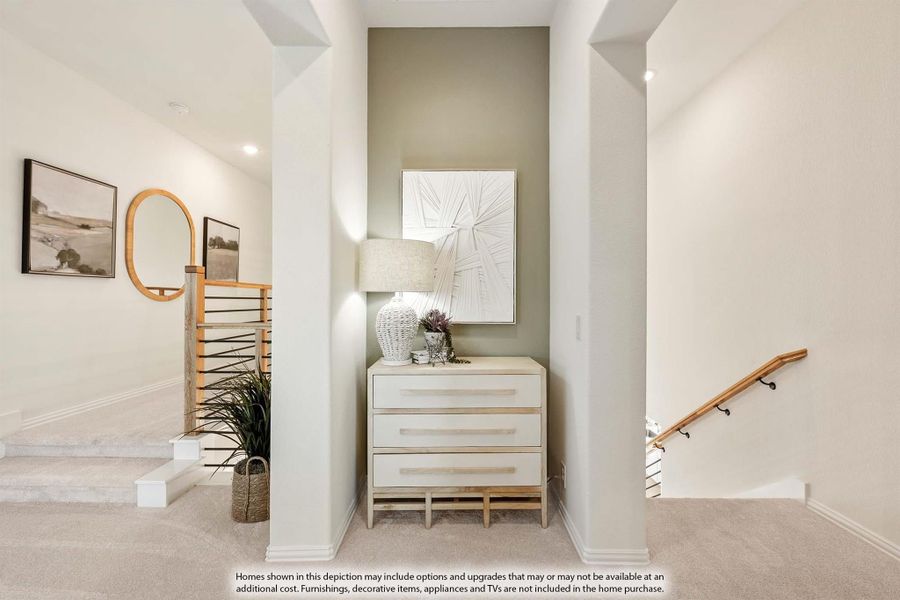 Upstairs hallway landing with carpet, white columns, accent wall, dresser, and staircase with wood railing Upstairs hallway landing with carpet, white columns, accent wall, dresser, and staircase with wood railing