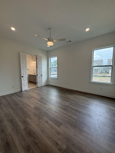 Spacious room featuring wood-finish flooring, recessed lighting, and a ceiling fan