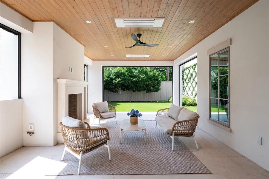 Covered climate-controlled patio with retractable screens and gas fireplace
