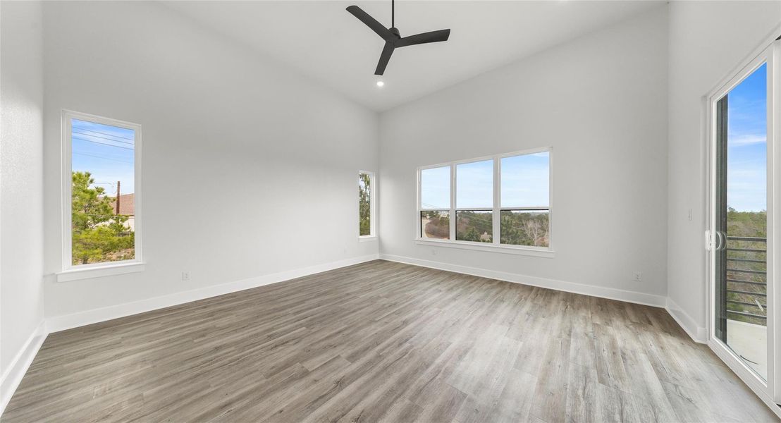 Unfurnished room featuring a towering ceiling, light wood finished floors, ceiling fan, and recessed lighting