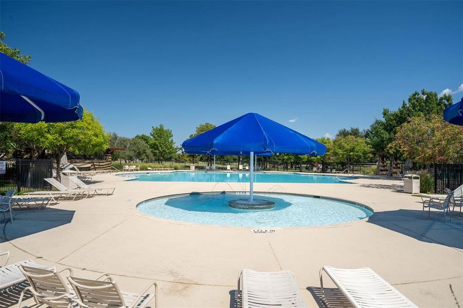 Community pool with a patio and a water slide Community pool with a patio and a water slide