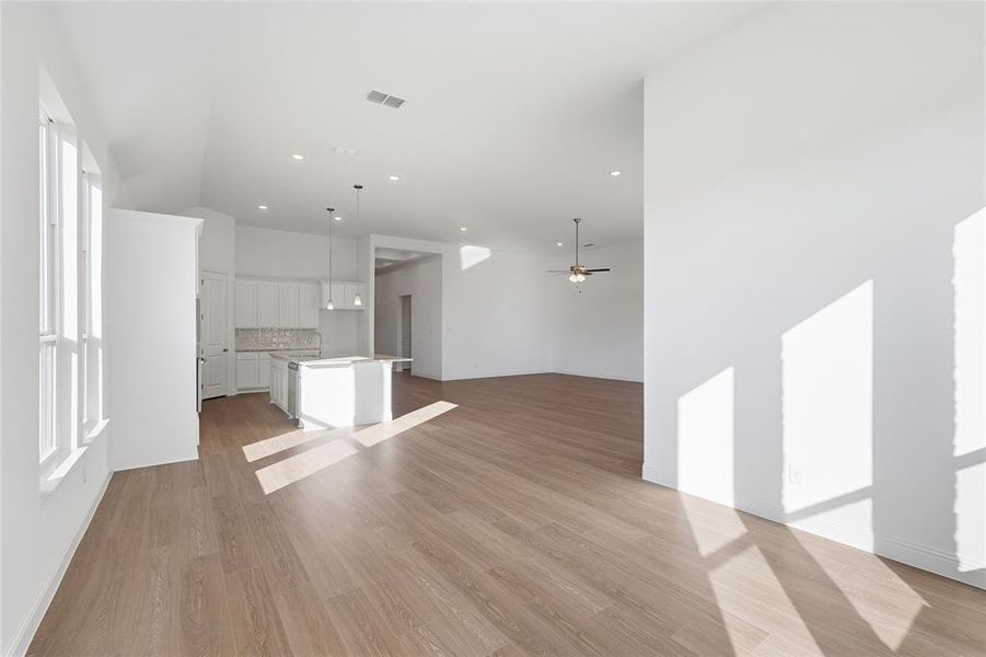 Unfurnished living room featuring ceiling fan, light wood-style floors, and recessed lighting Unfurnished living room featuring ceiling fan, light wood-style floors, and recessed lighting